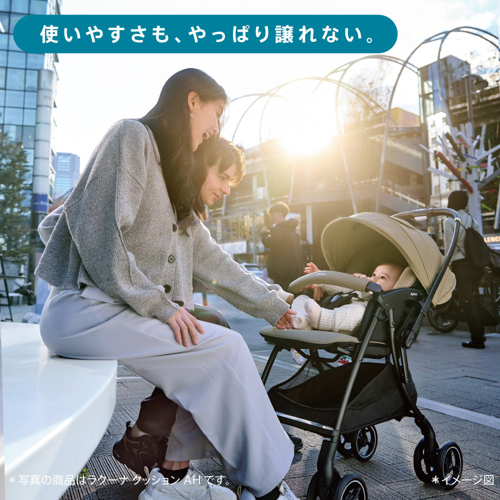 『ベルト装着、ぐずっている時だと焦って大変…』というテキストと共に、暴れる赤ちゃんのベルトを装着しようと苦戦する母親の手元のクローズアップ。